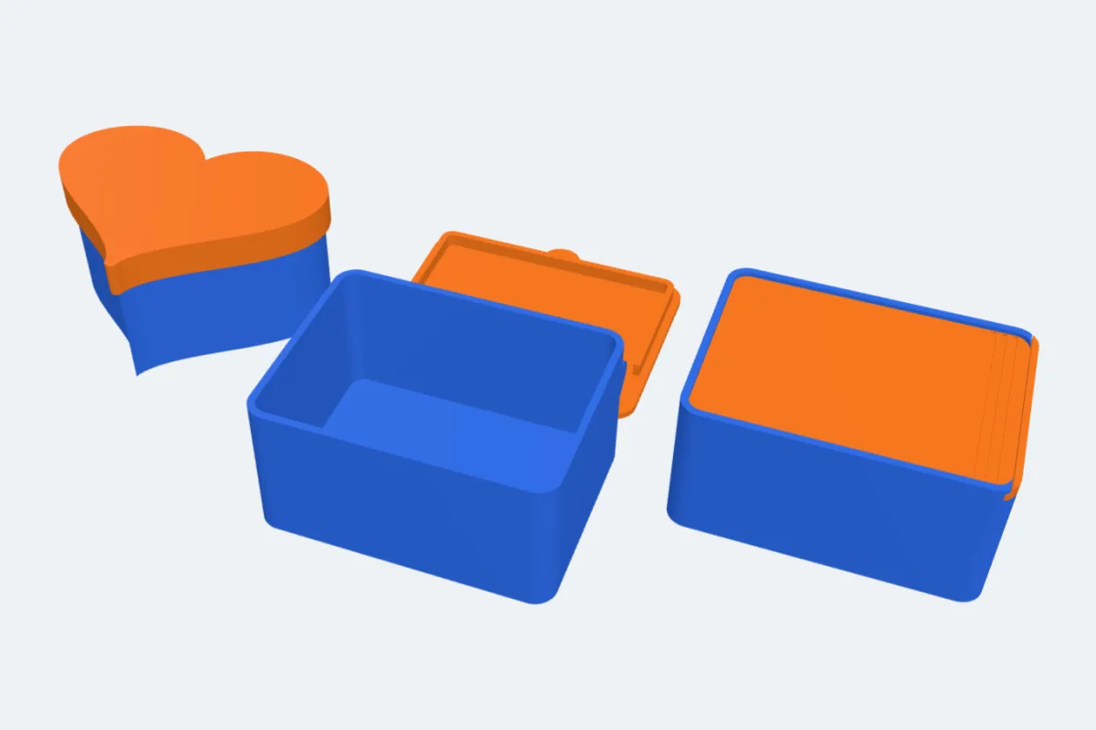A heart box with a cap, a box with a hinged lid lying open and a box with a slide-in lid