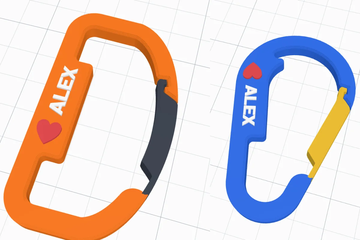 Two 3D printed carabiners: an orange D-shape with a dark gate and ALEX with a heart on its spine, and a blue pear shape with a yellow gate