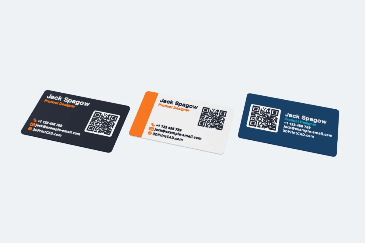 Three 3D printed business cards: a dark card with a QR code on a white tile, a light card with an orange band, and a blue card with a big QR code