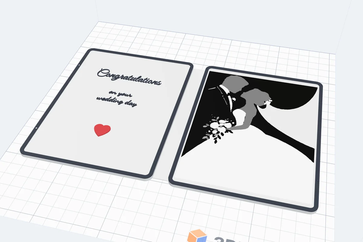 A 3D printed wedding card open on the bed: Congratulations on your wedding day and a red heart on the left page, the bride and groom on the right
