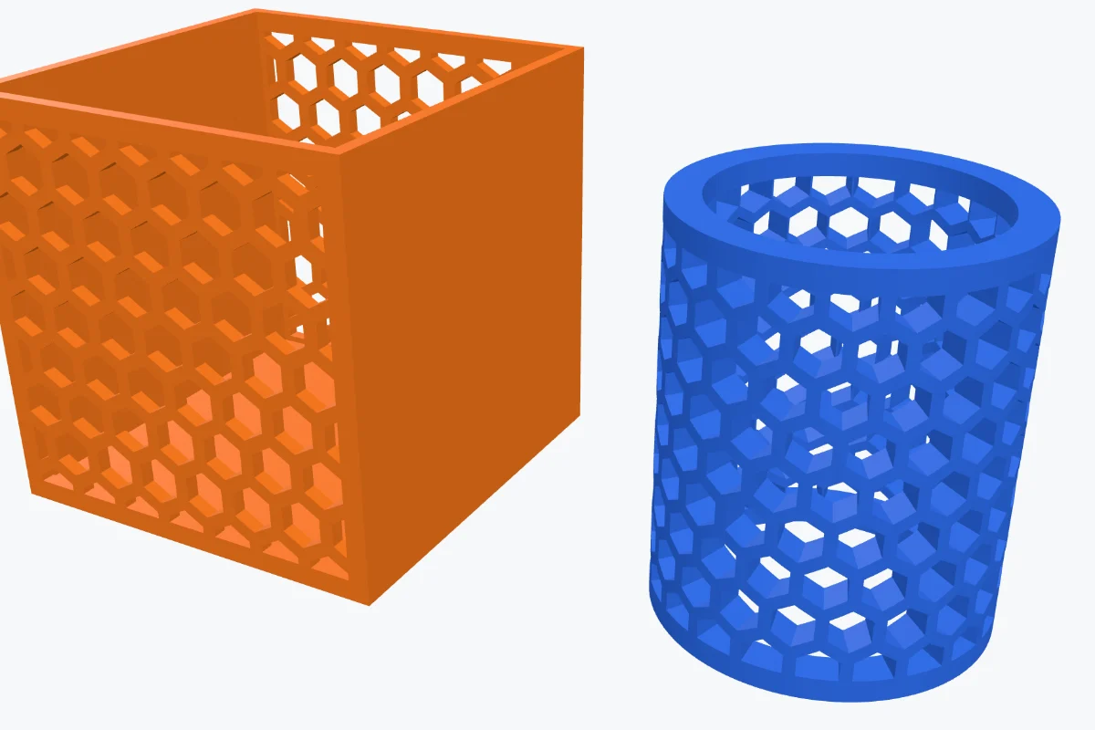 An orange open box with honeycomb holes through its walls and a blue tube with hexagon holes all the way round