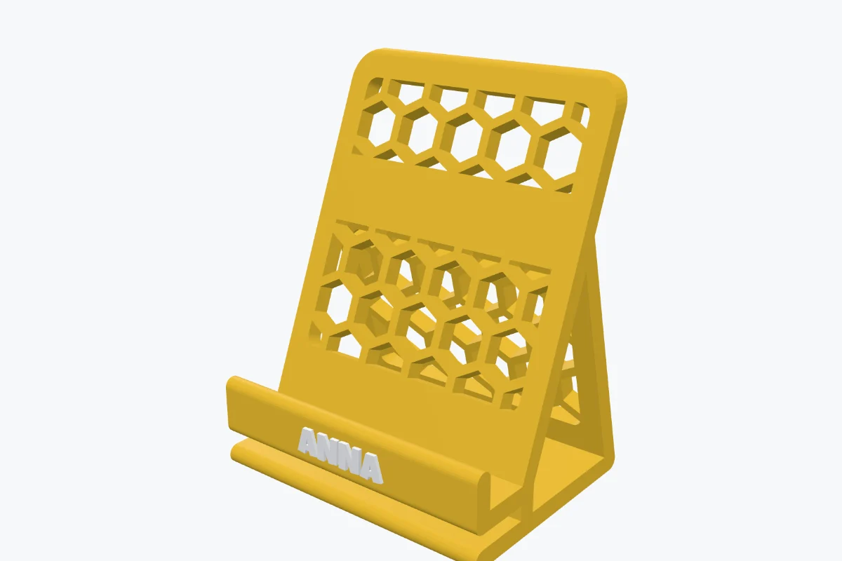 A honeycomb phone stand with hexagon holes through the backrest and the name ANNA on its lip