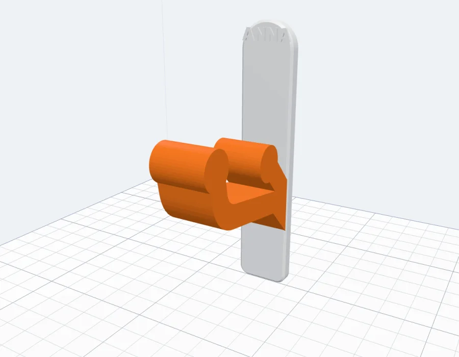 A coat hook in two colours: an orange hook on a white plate