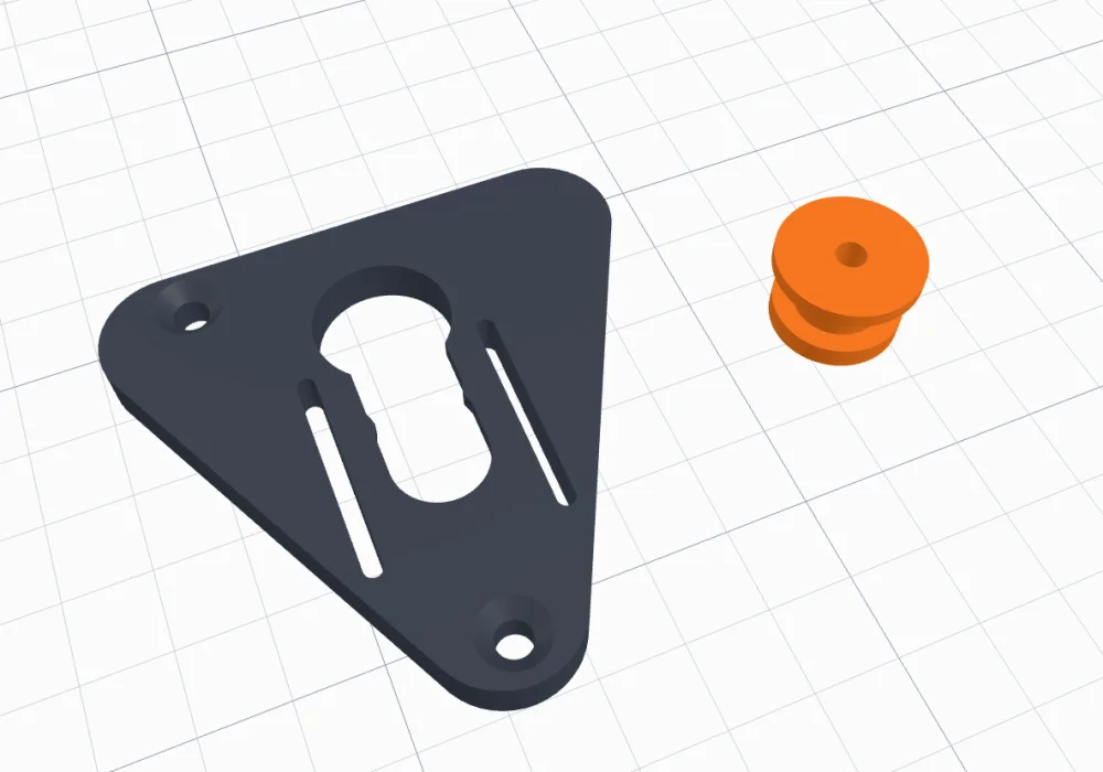 The slot and button: a triangle plate with a track and relief slots, and the printed spool