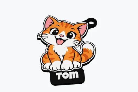 A 3D printed cat sticker keychain in five colours with the name Tom